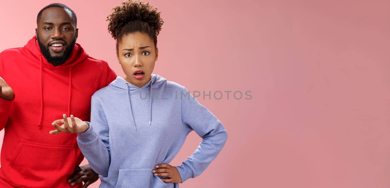 What hell are you doing. Portrait shocked confused clueless two african american friends man woman raise hand dismay shrugging concerned standing frustrated worried cannot understand happening.