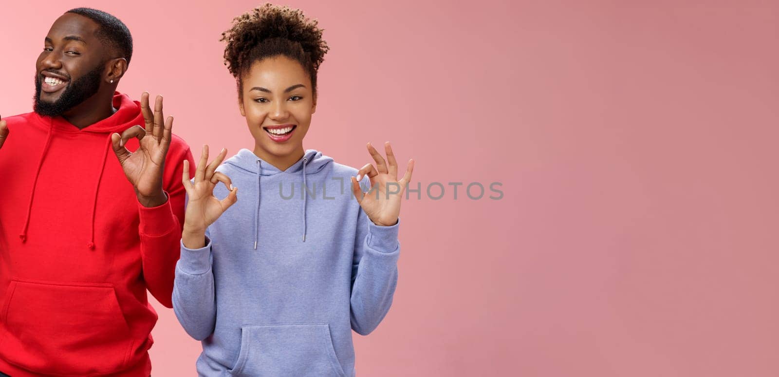 Everything perfect. Charming loving two couple relationship african american girlfriend boyfriend showing okay ok excellent gesture smiling approval assure parents they fine, pink background.