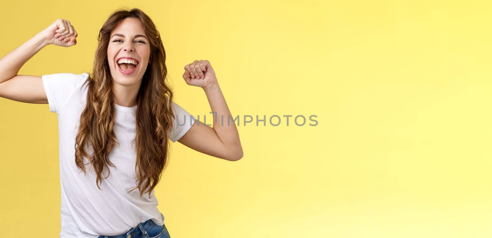 Girl thanks invitation awesome party having fun go wild raise hands up relaxed loose dancing lip sync cool music enjoying moment wear white t-shirt casual outfit celebrating yellow background. Lifestyle.