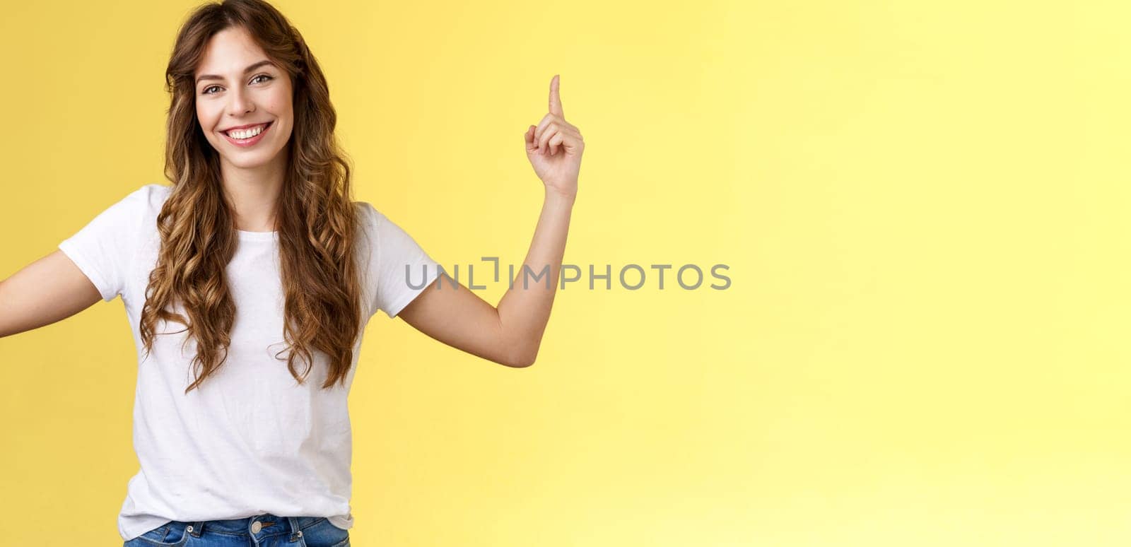 Friendly charismatic good-looking woman showing you great promo place pointing up index fingers raised top copy space smiling toothy delighted tilt head introduce advertisement great choice by Benzoix