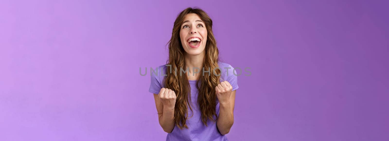 Relieved happy girl thank god awesome achievement celebrate success implore lord grateful fist pump yelling raise head up sky triumphing good news stand purple background joyful positive reaction. Lifestyle.