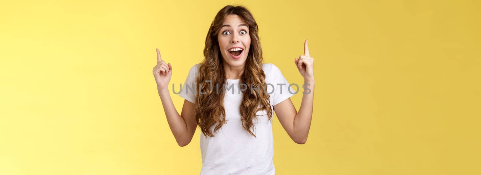 Happy enthusiastic impressed lively joyful girlfriend reacting astonished surprised excellent amusing promo gift pointing up index finger look admiration joy drop jaw fascinated temptation.