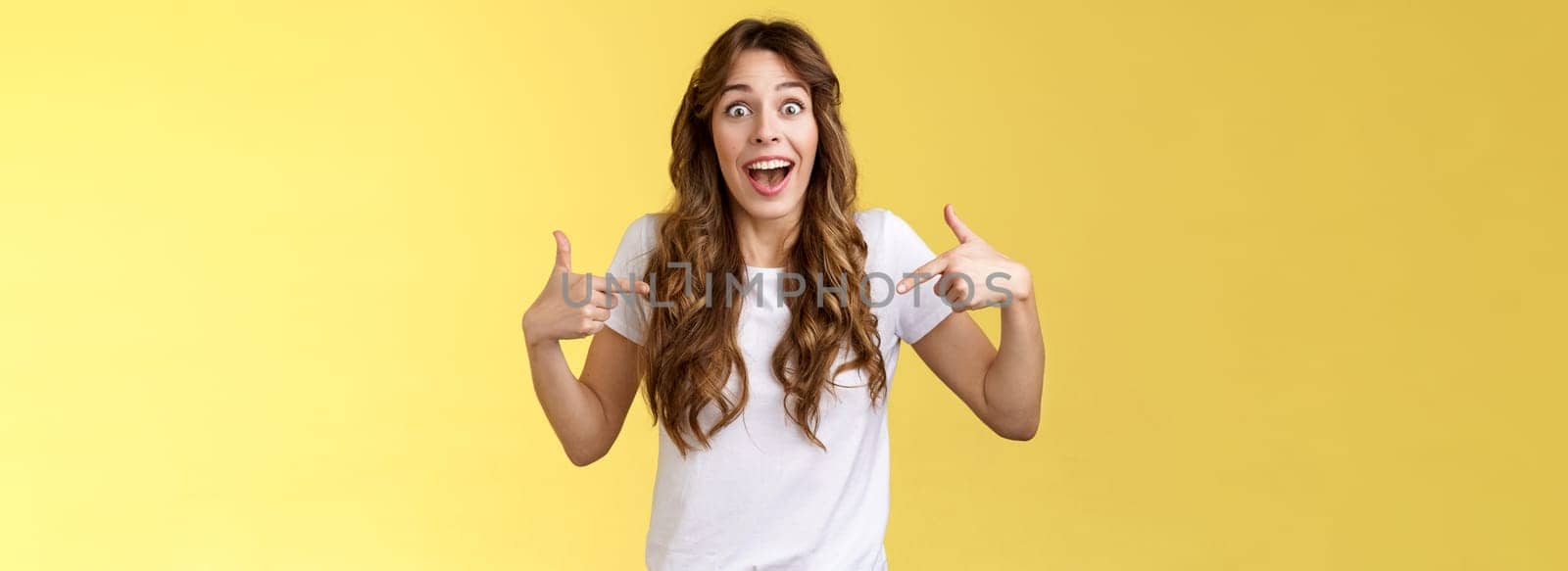 Can you believe, fascinating. Impressed sociable cute girl telling friend excellent near being picked got job pointing index fingers herself center copy space white t-shirt stare surprised smiling.