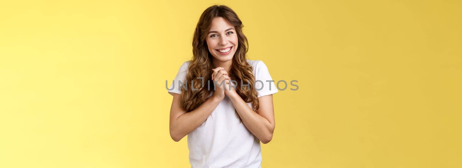 Cute lovely silly attractive female coworker appreciate friends farewell party office clasp hands thanking everyone awesome event smiling broadly delighted love adore you stand yellow background by Benzoix