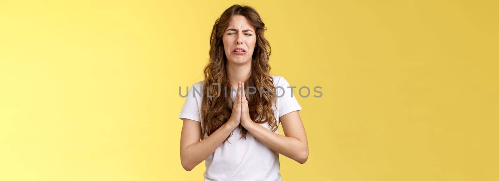 Please beg you. Sobbing timid insecure distressed cute whining girl crying upset close eyes grimacing hold hands pray pleading asking favour apologizing sincere hope for pity yellow background by Benzoix