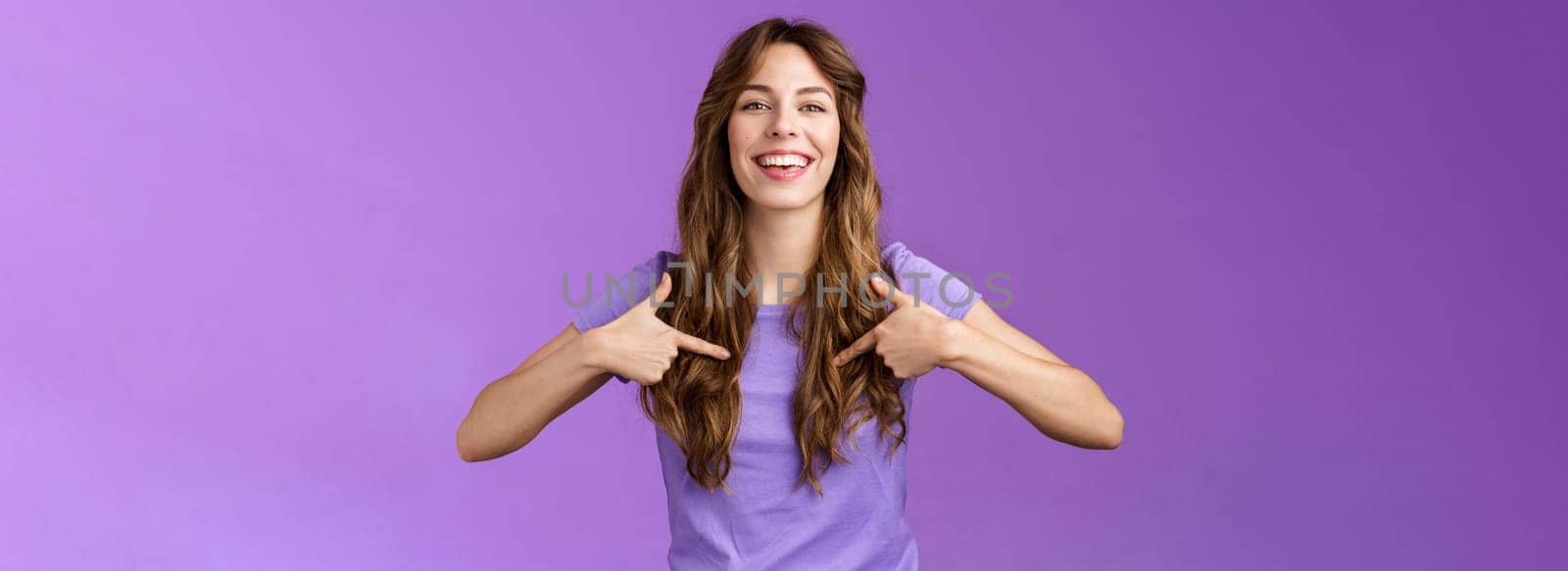 Boastful good-looking curly european female pointing herself proud who she is grinning delighted coming out pride month smiling broadly indicating center chest bragging purple background by Benzoix