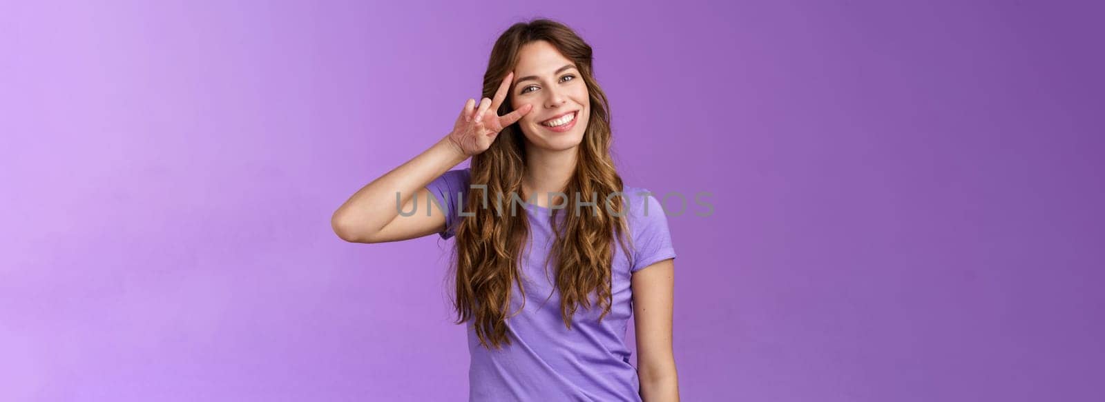 Tender friendly outgoing attractive female tilt head lovely cute gaze show peace victory sign express positivity love cherish friendship stand purple background upbeat relaxed casual pose. Lifestyle.