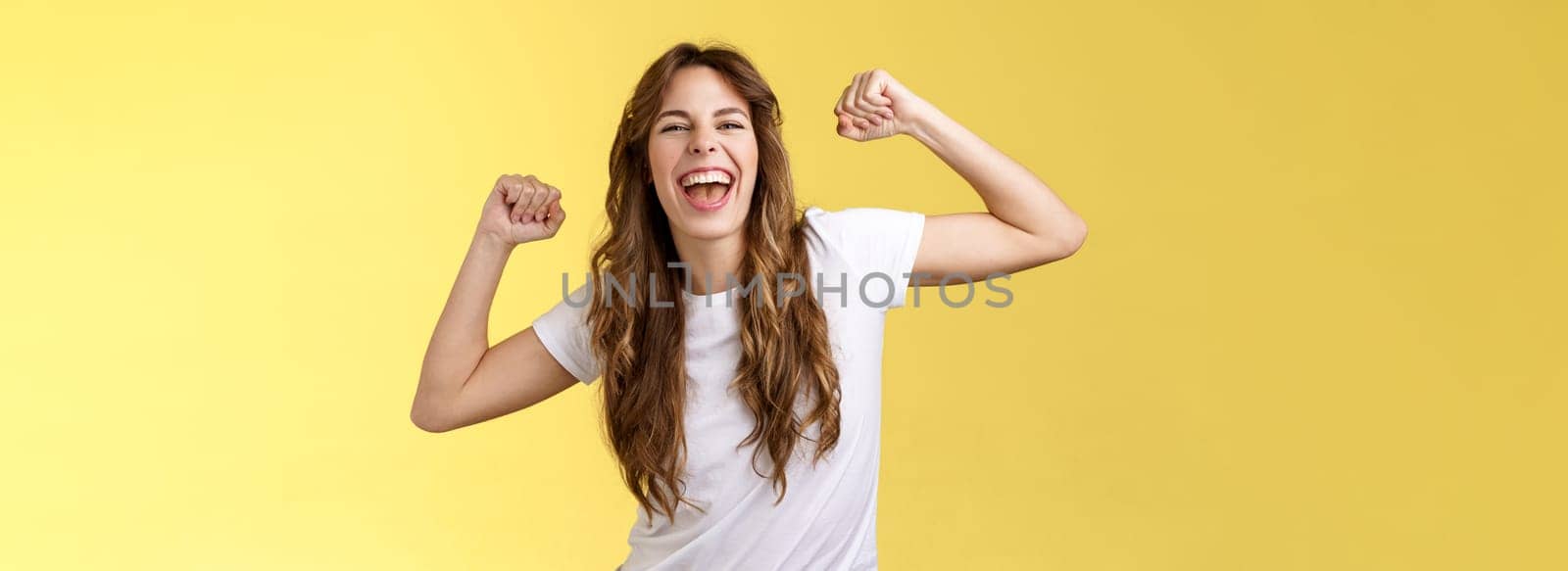Girl thanks invitation awesome party having fun go wild raise hands up relaxed loose dancing lip sync cool music enjoying moment wear white t-shirt casual outfit celebrating yellow background. Lifestyle.