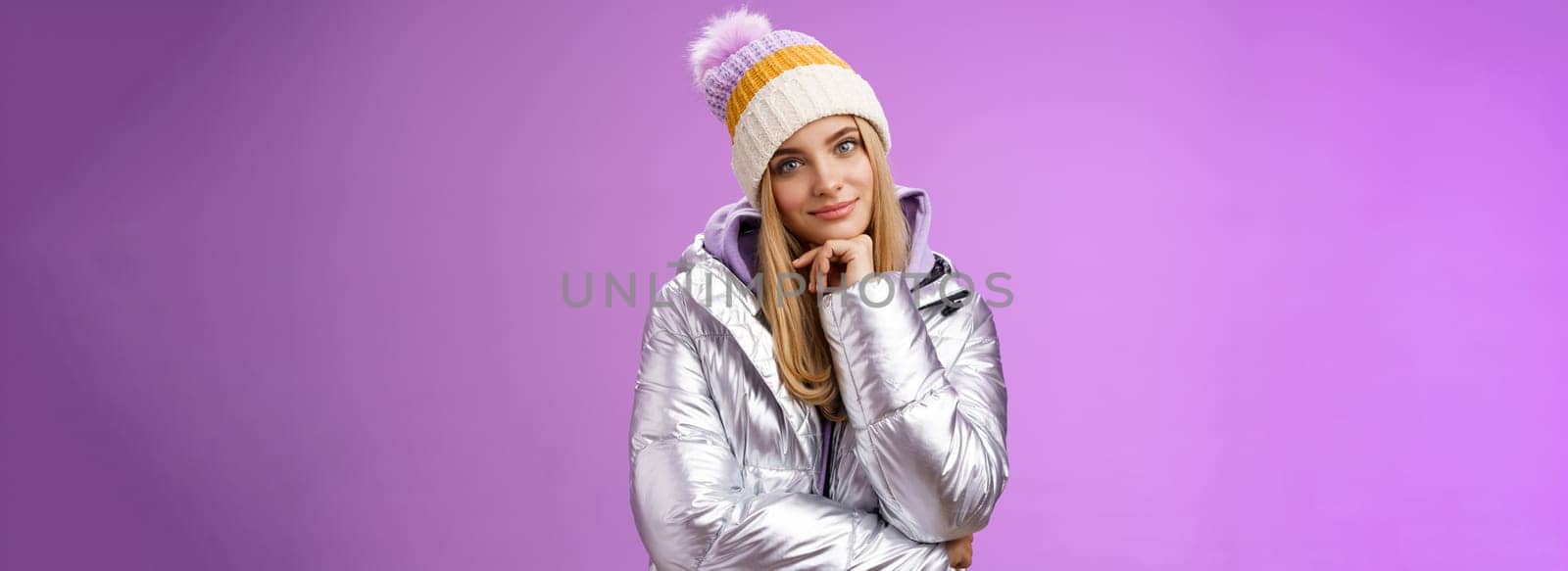 Lifestyle. Flirty curious attractive creative blond girl tilting head smiling amused find excellent idea touch chin thoughtful thinking standing interested looking intrigued camera in silver outdoor jacket.