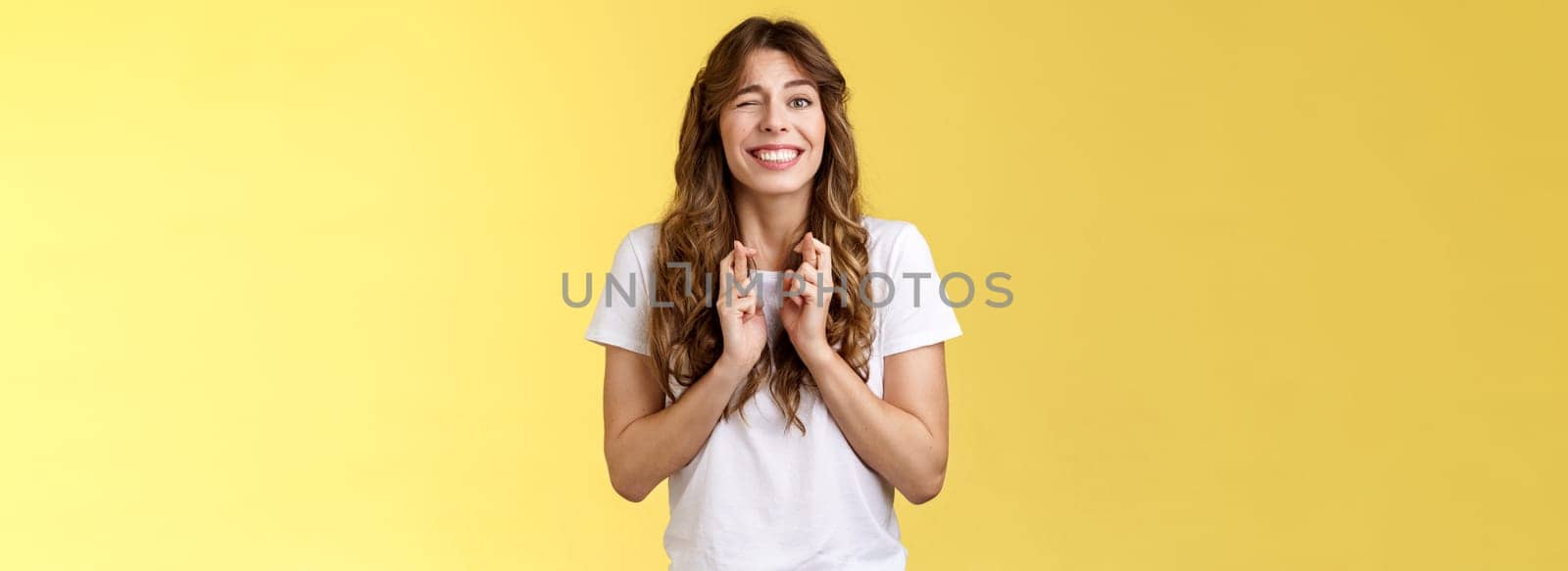 Excited happy cheerful optimistic girl peeking nervously awaiting results look one eye camera hopeful smiling broadly cross fingers good luck intense praying dream come true fulfillment wish by Benzoix