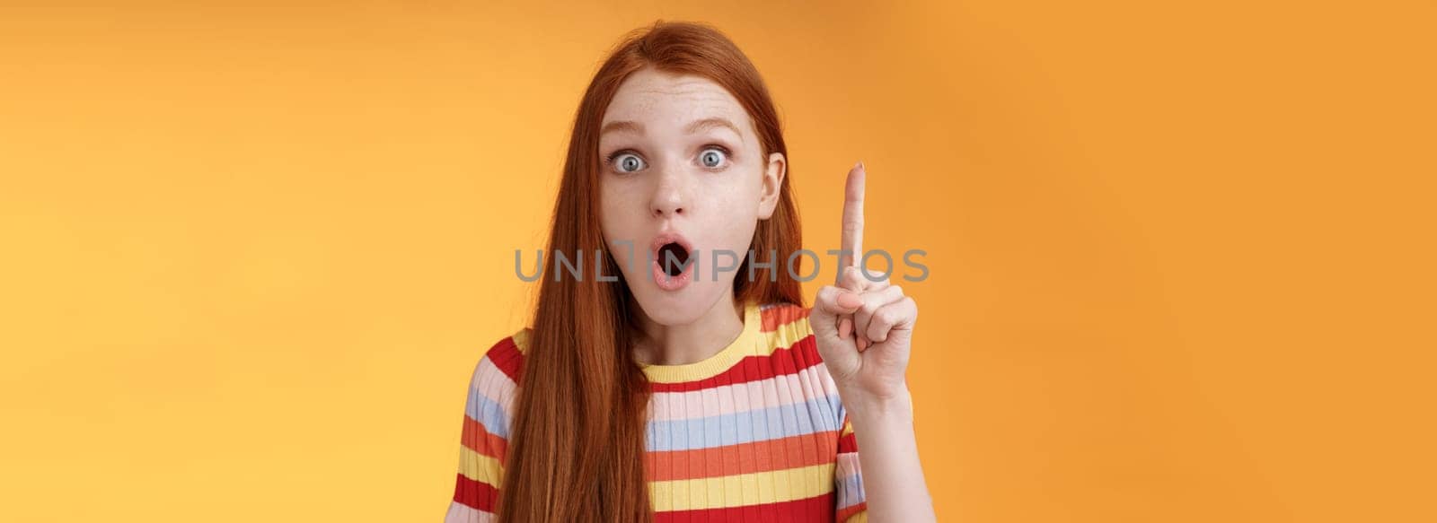 Wow got excellent idea. Excited shocked redhead girl open mouth raise index finger eureka gesture stare camera thrilled adding suggestion have plan think-up solution, standing orange background.