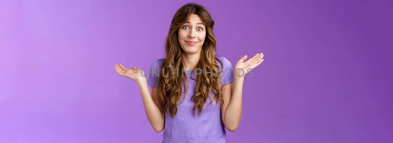 Girl not giving any care. Carefree unbothered cute caucasian curly-haired woman shrugging hands spread sideways smirking uninterseted nothing to say shake head questioned clueless purple background by Benzoix