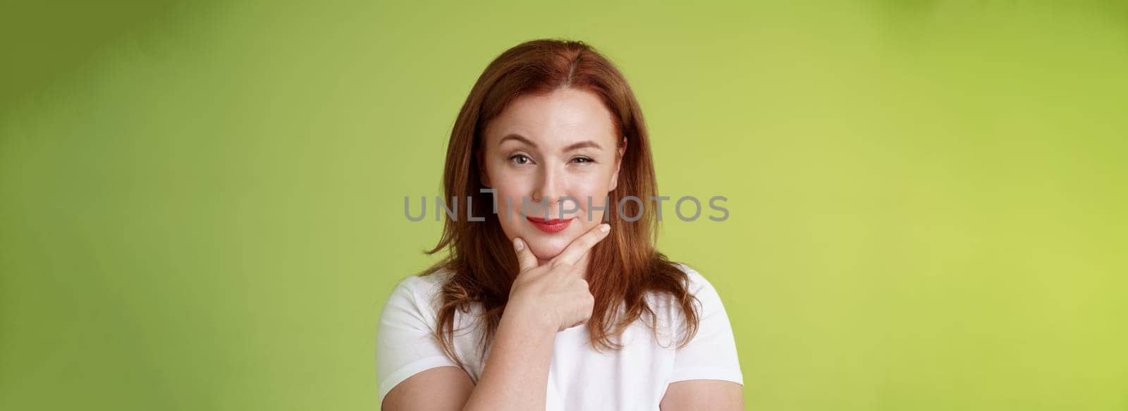 Hmm interesting choice. Intrigued cunning redhead middle-aged female hold hand face-line rub chin thoughtful smirking pleased raise eyebrow curious pondering alluring decision green background by Benzoix