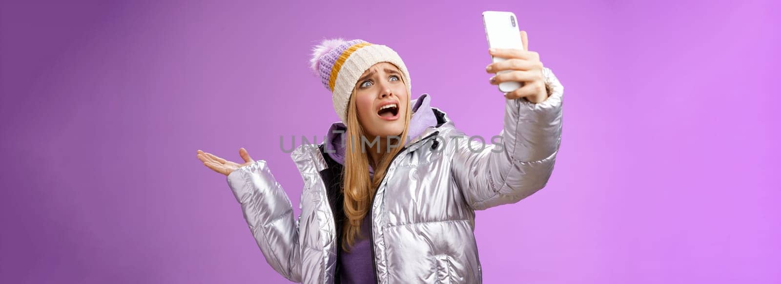 Upset bothered whining blond girl complaining cannot find right angle take selfie with cool sightseeing during vacation travelling abroad yelling smartphone pointing aside, purple background by Benzoix