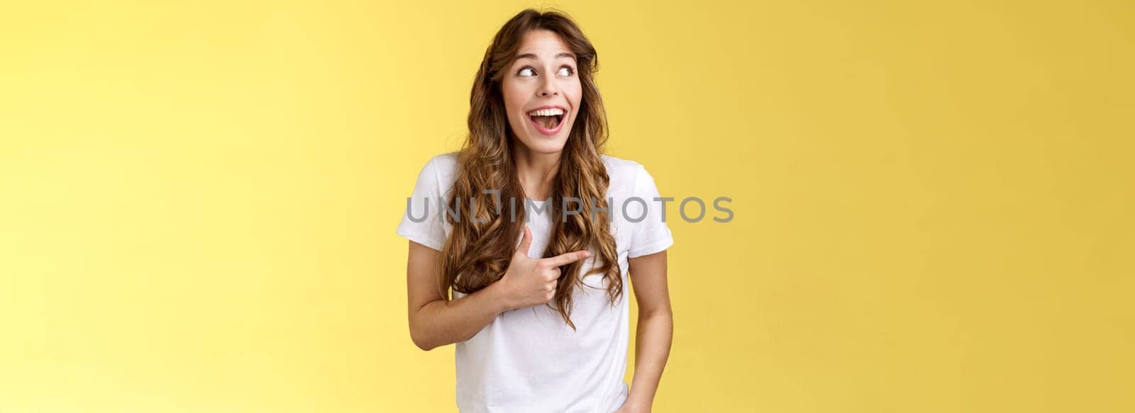 Funny amused cute girlfriend enjoy awesome party having wonderful time spend amazing day city fair open mouth surprised fascinated observe admiration lgbtq pride parade happy yellow background. Lifestyle.