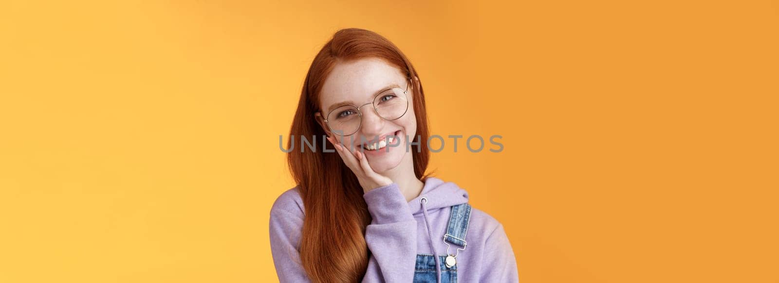 Smiling satisfied happy redhead girl get rid acne delighted touching soft clean skin laughing joyfully talking feel confidence self-assured own beauty, standing orange background enjoy communication by Benzoix