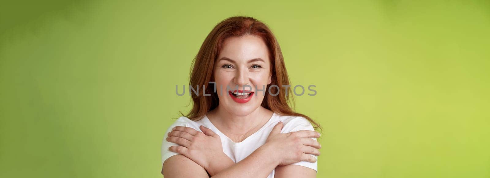 Cheerful charismatic happy good-looking redhead woman red lipstick cross hands chest smiling motivated excited having fun playful thrilled mood grinning enthusiastic standing green background by Benzoix