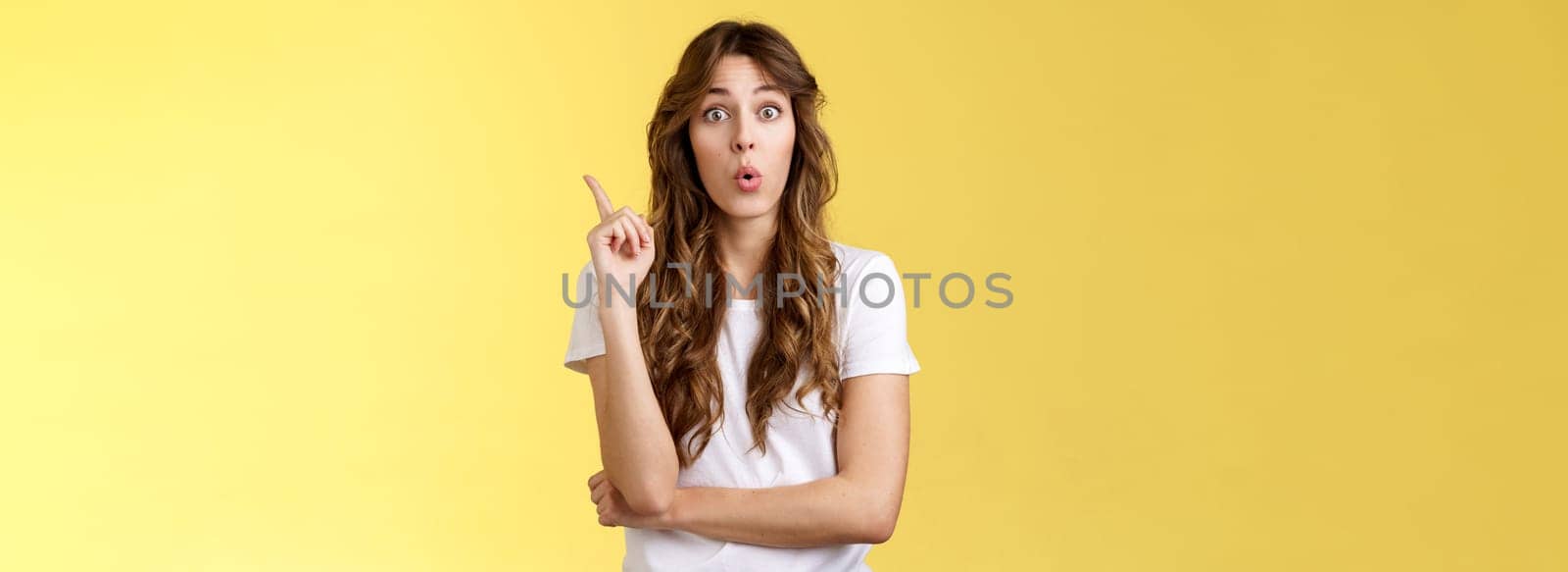 Great idea stiked mind. Ambushed creative good-looking female coworker give advice raise index finger eureka gesture fold lips intrigued speak out interesting plan thought stand yellow background.