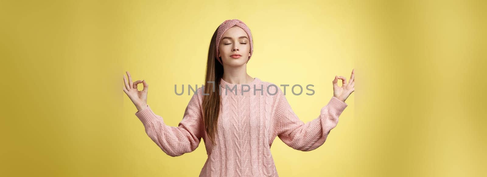 No stress. Pretty young female student not worry, releasing negative emotions during yoga training session standing in lotus pose, breathing smiling relieved happy, showing mudra sign feeling relaxed.