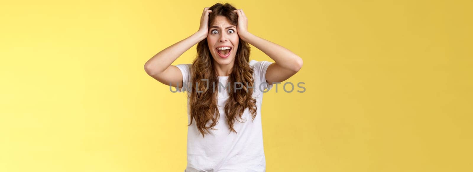 Girl screaming panic. Troubled distressed anxious woman see huge mess terrified feel sorrow shouting shocked grab head hopeless problem terrible situation yelling shook stunned yellow background.