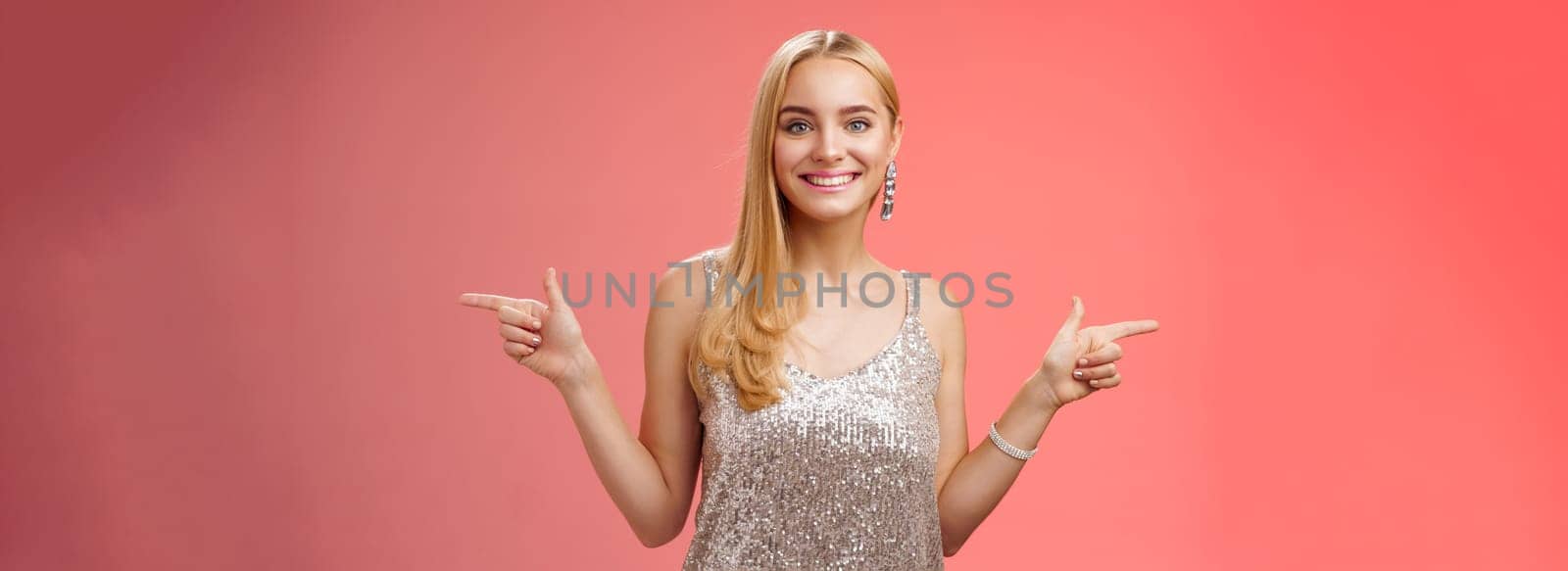 Waist-up shot energized cheerful blond european girl in silver glittering dress pointing sideways left right smiling amused showing lots variants variety opportunities make choice which better by Benzoix