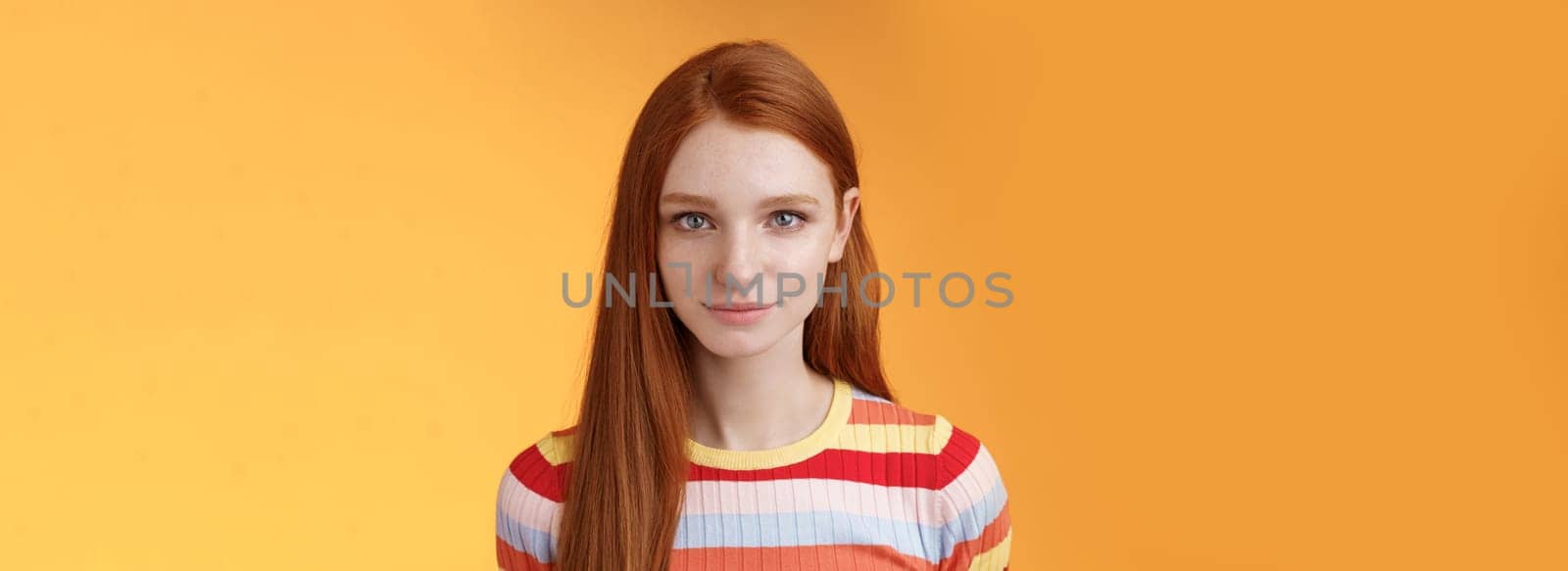 Attractive young sincere redhead girl clean pure perfect skintone smiling modest look camera friendly delighted standing relaxed awaiting gazing silly tenderly, posing orange background by Benzoix