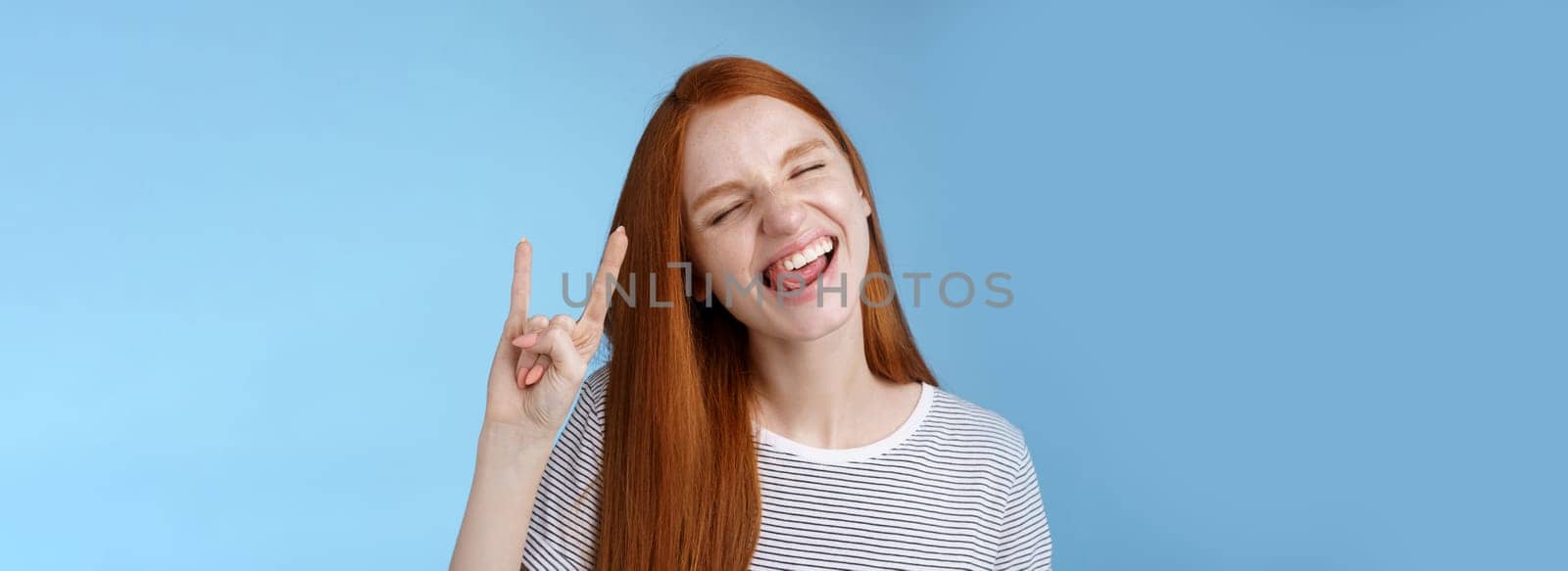 Happy cheerful carefree chilling redhead teenage girl having fun stick tongue close eyes dancing joyfully show rock-n-roll heavy metal sign enjoy party amusing festival music performance by Benzoix