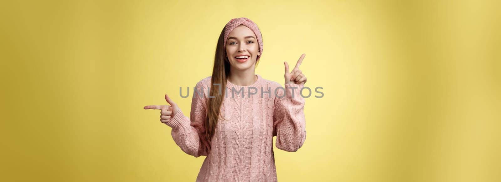 Pick what want. Charismatic cheerful young female student in headband, sweater pointing up, indicating right smiling cute, promoting advertisement showing opportunities and choices over white wall.