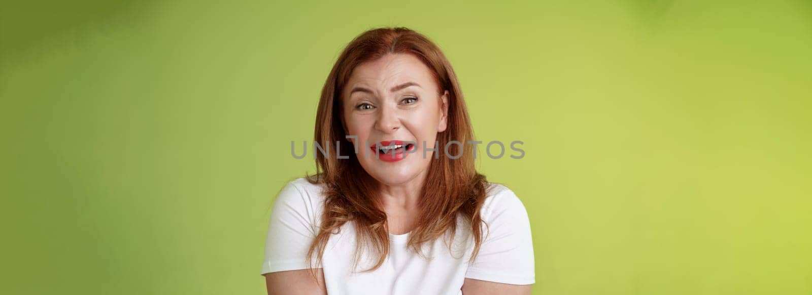 Tender redhead cheerful middle-aged mother sighing happiness temptation smiling delighted look alluring fascinated camera check out cute lovely scene melting heartwarming moment green background.