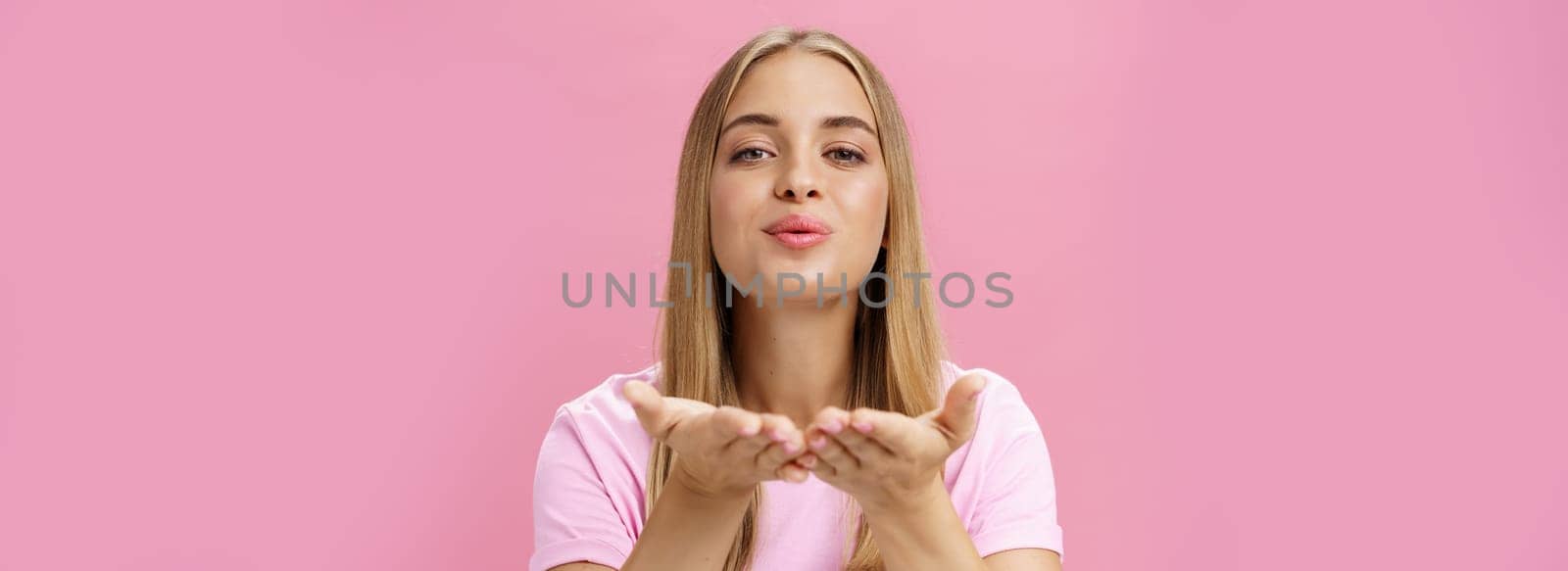 Spreading love to world. Portrait of charming sensual and tender romantic girlfriend holding palms over chest folding lips raising head and sending air kiss at camera with passion and romance. Body language and relationship concept