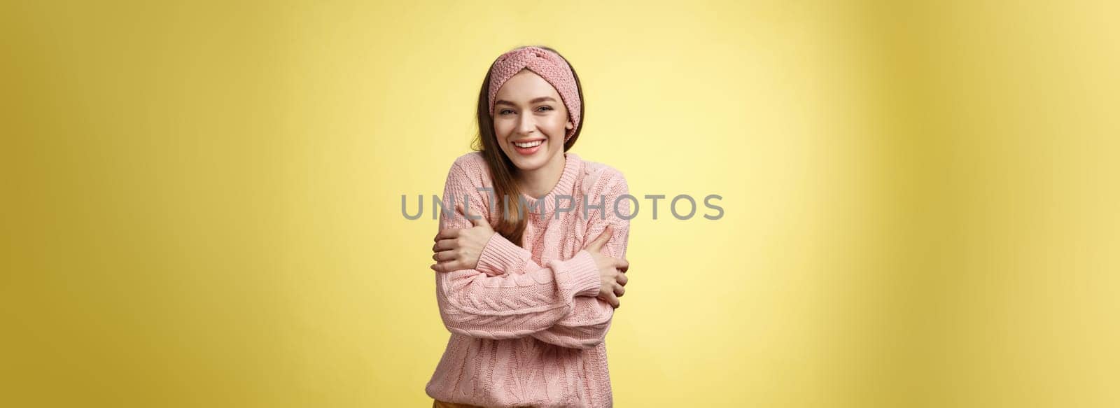 Getting chilly, better put on coat. Charming cute young tender european woman wearing sweater embracing body cross arms over chest, hugging herself to warm-up feeling cold, trembling, smiling by Benzoix
