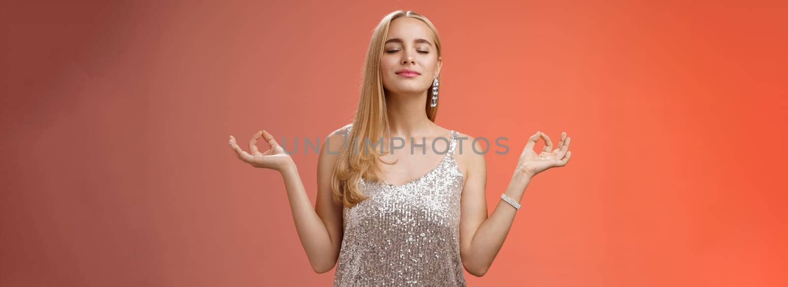 Keep calm party all night. Carefree unbothered happy charming stress-free blond young woman in stylish dress smiling relieved close eyes rejoicing standing lotus nirvana pose, breathing meditating by Benzoix