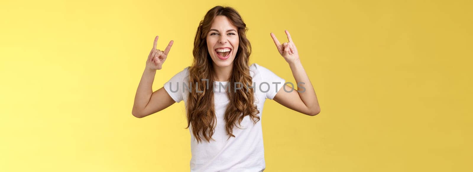 Girl having fun excellent awesome concert enjoy live music show rock-n-roll heavy metal gesture yelling upbeat happy attend cool festival party smiling broadly show tongue daring yellow background by Benzoix