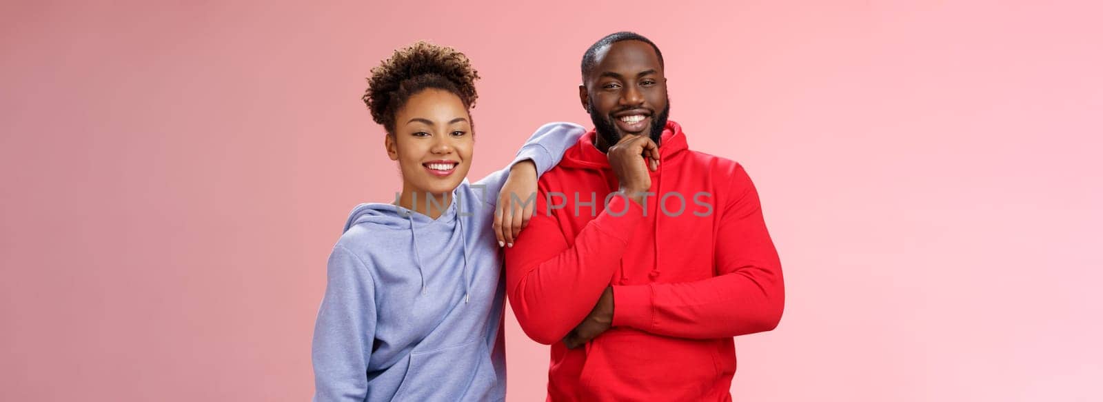 Romantic couple best friends standing pink background girl leaning boyfriend shoulder smiling broadly feel love respect each other working team standing pleased delighted friendly look camera by Benzoix
