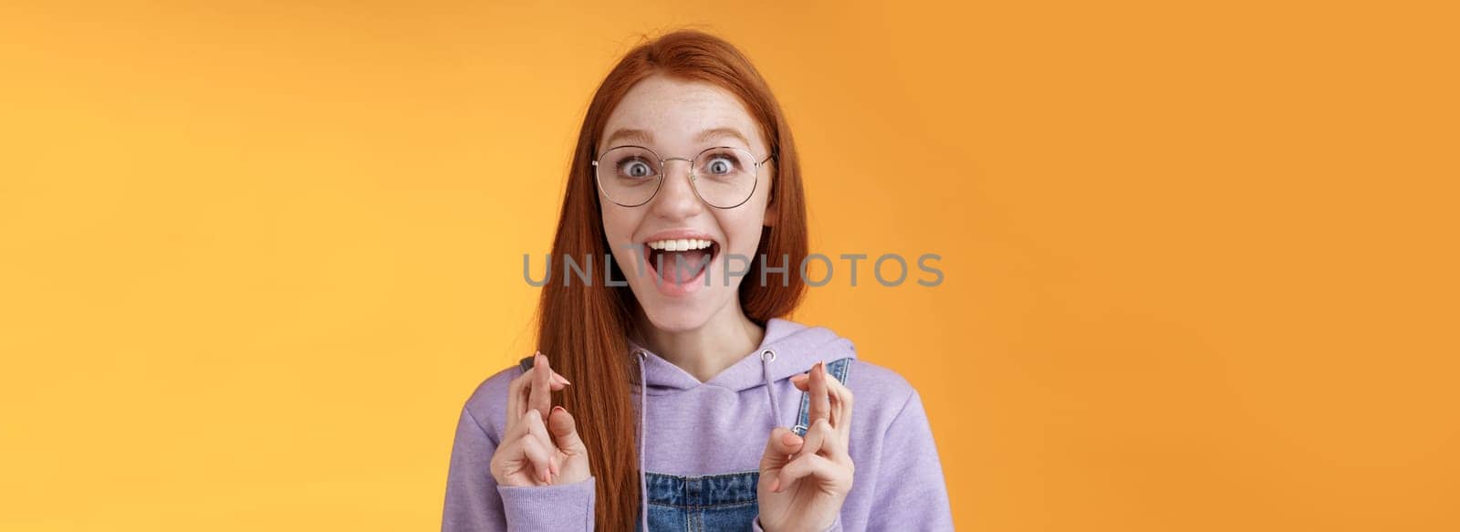 Excited amused successful young redhead female student receive positive good news thrilled after praying crossed fingers good luck screaming happily rejoicing dream come true wish fulfilled by Benzoix