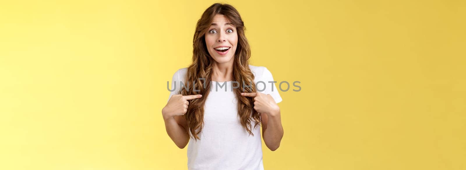 Surprised relieved pleased cute curly-haired girl receive promotion pointing herself lucky smile look camera astonished happily react awesome surprise indicating hopeful delighted yellow background by Benzoix