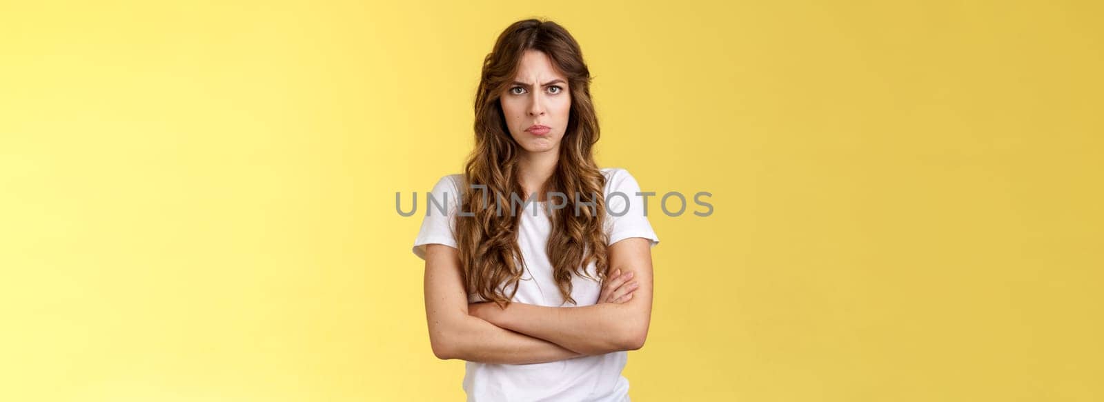 Upset jealous moody clingy girlfriend sulking offended cross hands chest blocking pose frowning disappointed complaining unfair treatment stand yellow background bothered pouting childish by Benzoix