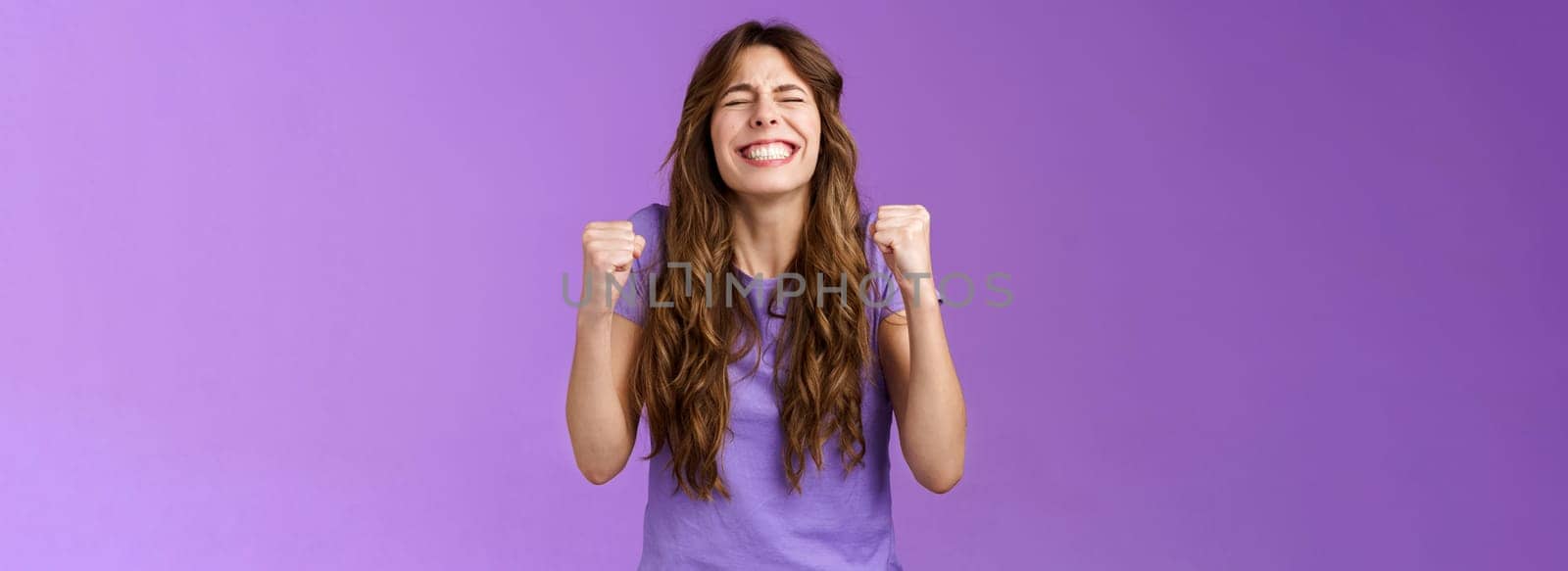 Yes I did it. Relieved happy triumphing joyful girl pump fists celebrating excellent achievement raise head up close eyes thank god winning first prize stand purple background happy.