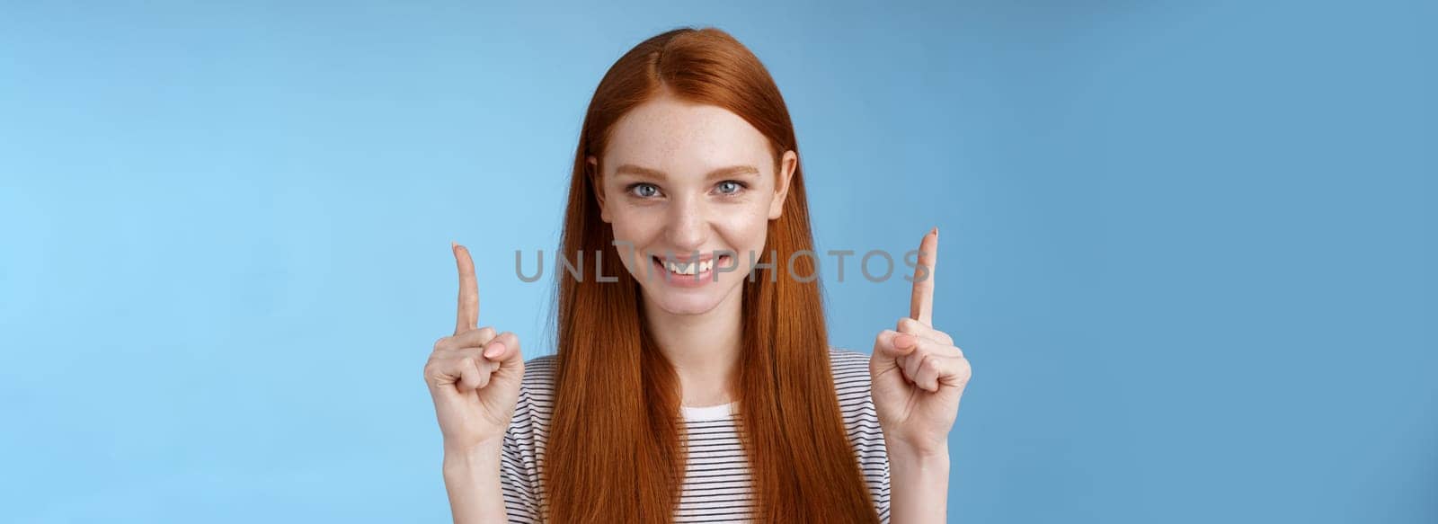 Lifestyle. Determined good-looking redhead female student enter college final decision pointing up index fingers raised confidently smiling white teeth look camera assertive giving recommendation what choose.