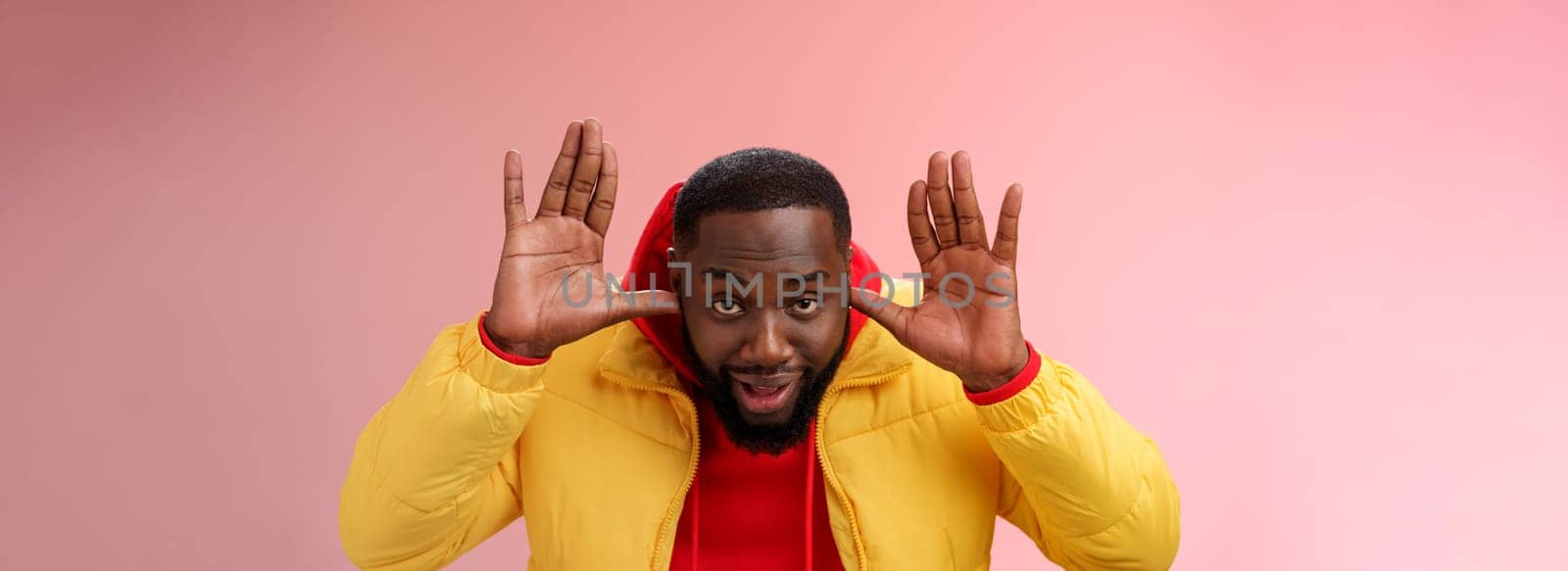 Ha cannot hear you sorry. Portrait ignorant funny careless unbothered young african guy pretending dumb plug thumbs ears show palms bending camera eavesdrop, standing pink background by Benzoix