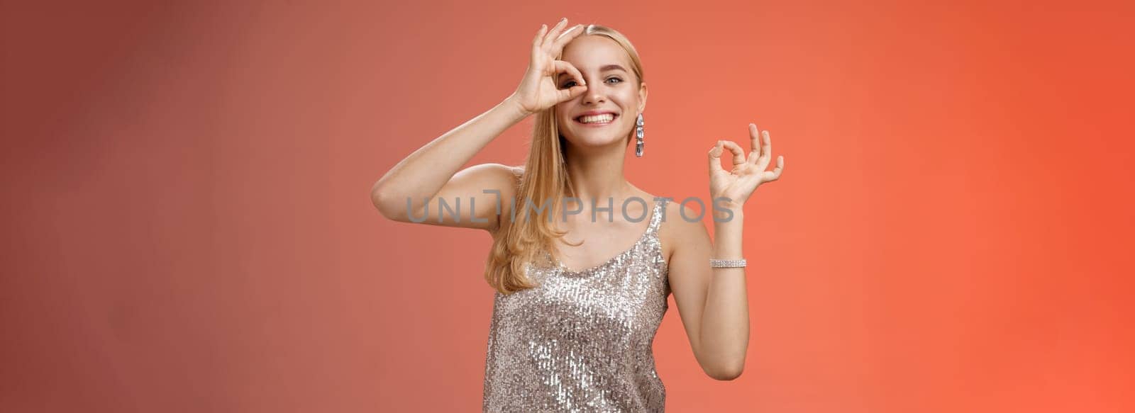 Charming funny tender feminine blond girlfriend dancing having fun enjoying perfect party smiling broadly show okay ok excellent gesture like new dress grinning satisfactory, red background.