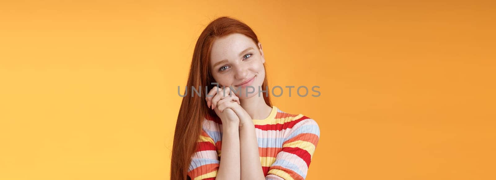 Dreamy sensual romantic young passionate redhead girlfriend melt heart feel sympathy joy receive sweet tender present lean palms smiling grateful gladly accept nice lovely gift, orange background.