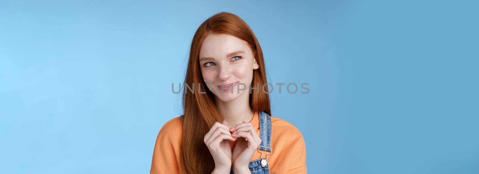 Devious tricky young girl have excellent plan smirking delighted mysteriously look upper left corner smiling have idea thoughtfully twiddles fingers standing rejoicing blue background by Benzoix