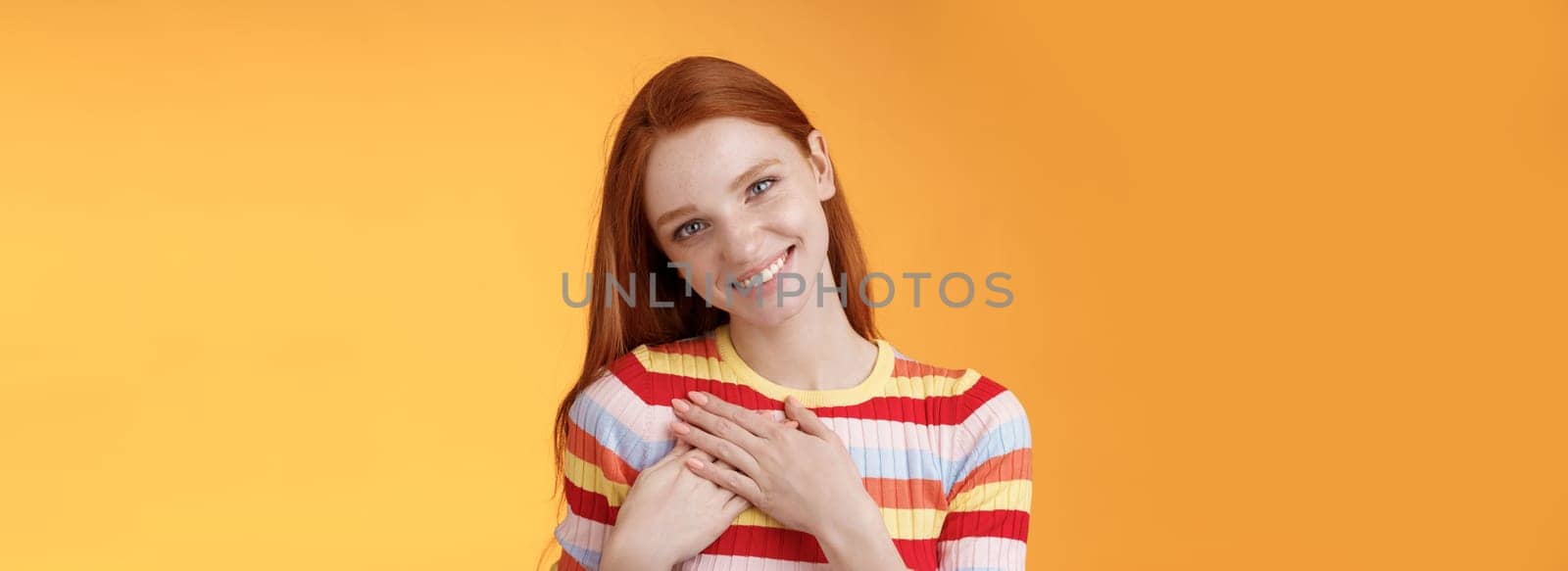 Pleased tender feminine good-looking redhead woman receive compliment confession touch heart feel warmth dearest moment smiling delighted lovely keep love inside soul, standing orange background by Benzoix