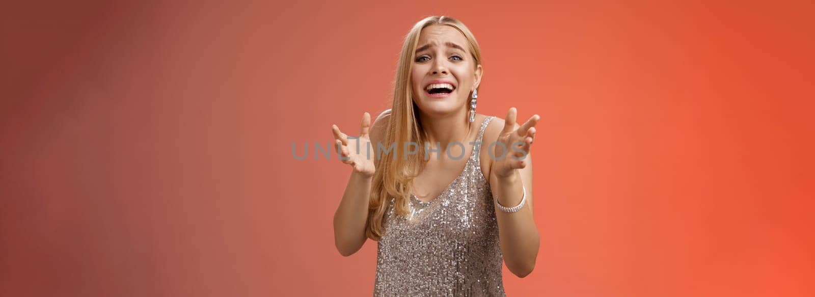 Lifestyle. Panicking upset miserable heartbroken blond girl crying raising hands begging not go broke-up boyfriend look sorrow distressed freak-out standing devastated red background during party.