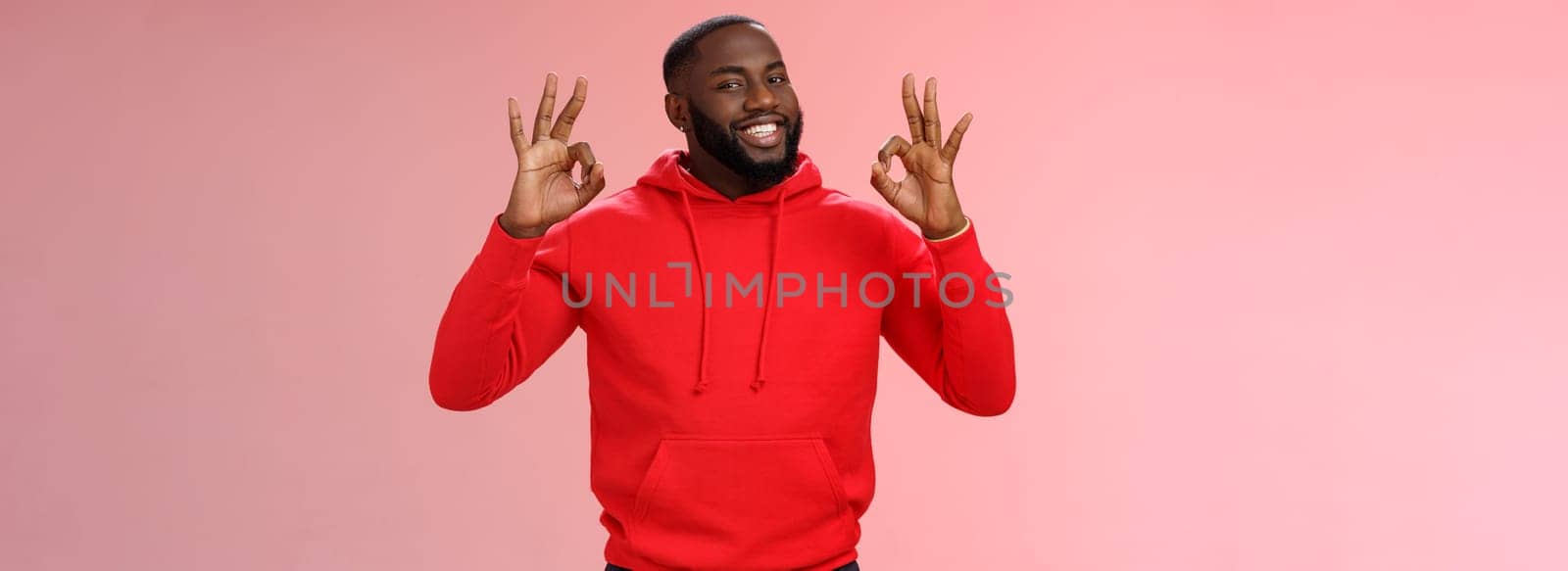 Guy promise perfection. Portrait confident charismatic pleasant african american man show okay no problem gesture say okay smiling assuring everything cool, standing pink background delighted.