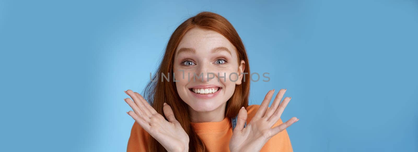 Happy rejoicing emotional young smiling redhead girl blue eyes getting exciting news grinning cheering happily raise hands thrilled wide eyes surprised accepted famous university, blue background by Benzoix