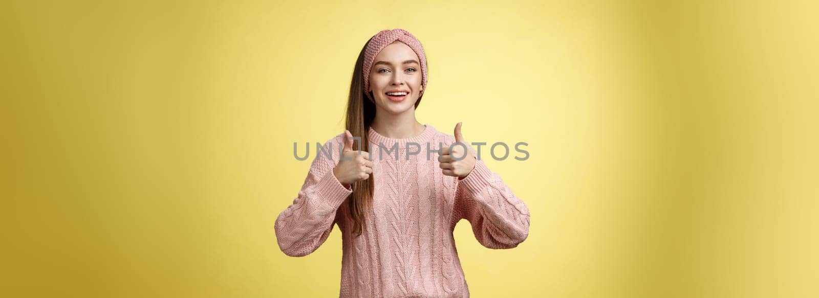 Attractive positive young girl in knitted sweater agree with suggestion, approving plan, showing thumbs up, recommending awesome film, smiling, cheering, supporting friend effort, encouraging by Benzoix