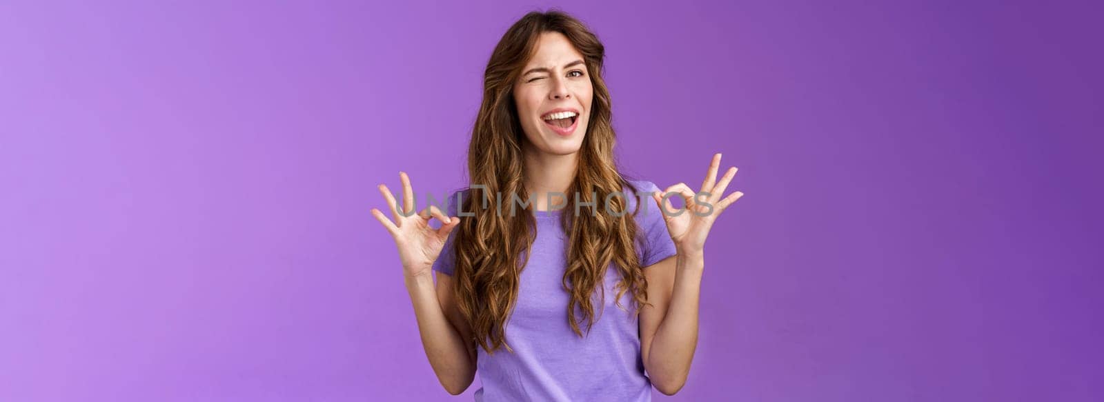 Got it relax everything perfect. Relaxed carefree curly girl winking cheeky smiling cunning show okay ok ring sign assure all good stand satisfied accepting great choice approving purple background.