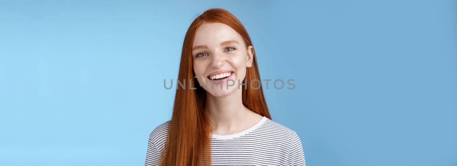 Happy friendly charismatic joyful young sincere 20s redhead girl having fun smiling cheerful laughing joking talking casually grinning camera express positive lucky attitude, standing blue background by Benzoix